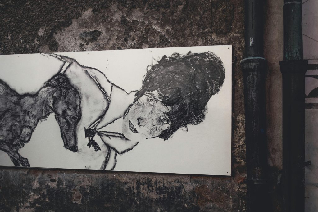 Street art depicting a woman and a dog on a textured wall in Český Krumlov.