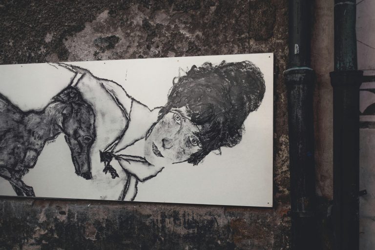 Street art depicting a woman and a dog on a textured wall in Český Krumlov.