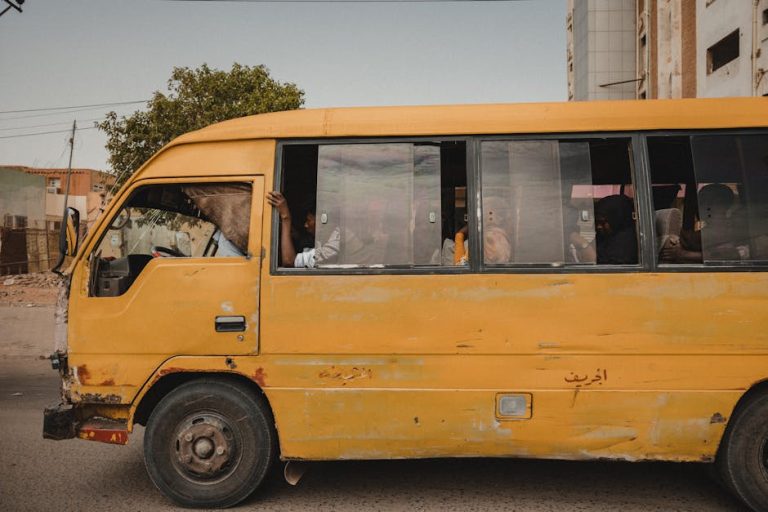 A worn yellow bus navigating a city street, portraying urban transportation and daily life.